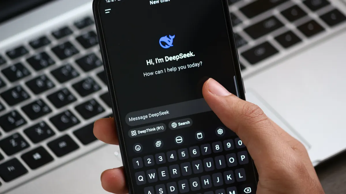 Phone showing AI chat app beside laptop keyboard